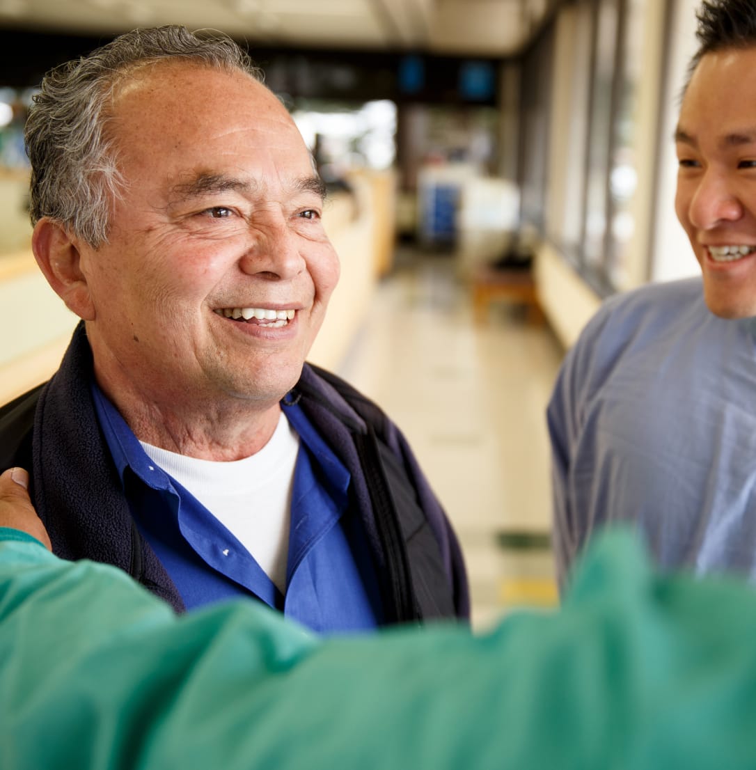 Smiling senior man with healthcare professionals.